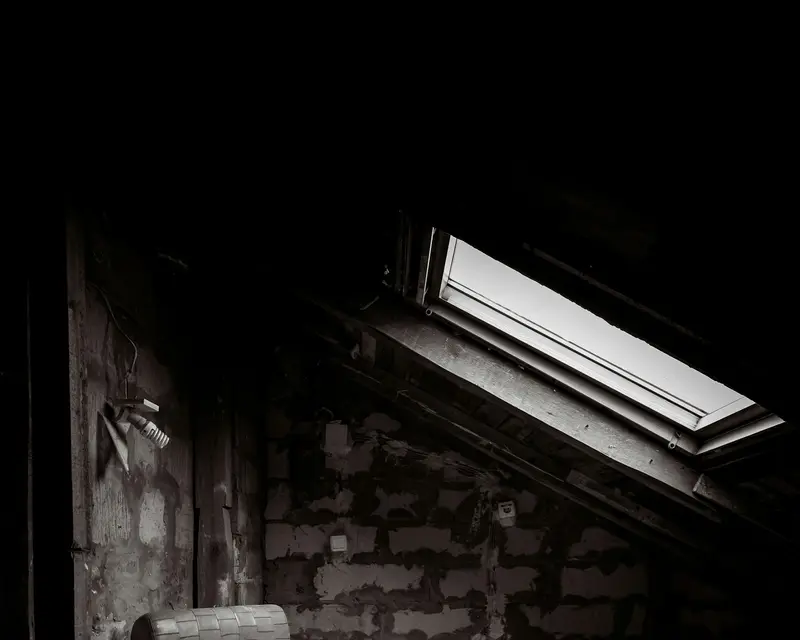 Old armchair in a dim attic before a loft clearance by Waste Bristol