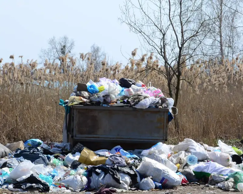 Overflowing skip of rubbish in a field, the kind of waste Waste Bristol removes